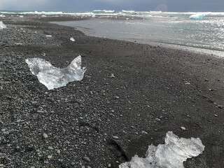 Iceberg at Diamond Beach Joekulsarlon. Blue chunk of ice on the black sand beach near the Glacier...