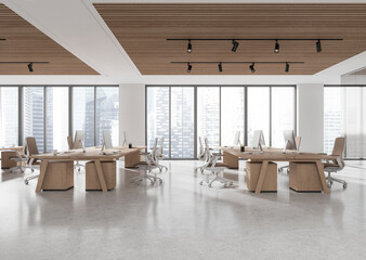 Spacious open space office with wooden desks and chairs, large windows showing cityscape. Modern...