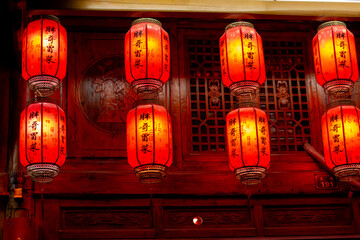 red lanterns hanging on a tree outside a restaurant.
