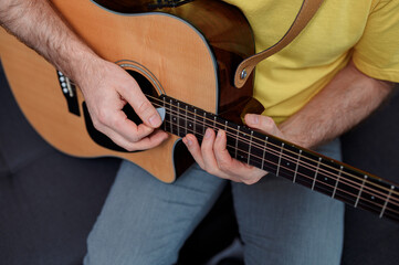 Guitarist on acoustic guitar playing melody. Close up musician instrument with pick in hand
