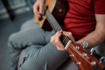 Fototapeta premium Guitarist on acoustic guitar playing melody in studio. Close up musician instrument