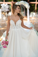 Naklejka premium Beautiful bride on white wedding dress with bridal bouquet