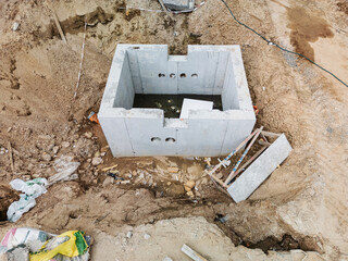 Construction site showcasing newly built concrete foundation in an excavated area surrounded by...