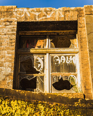 Ein kaputtes Fenster in einem leerstehendem Haus.