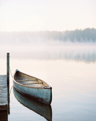 Misty Lake with a Canoe, peaceful reflections and soft morning light