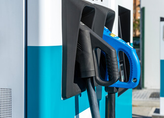 Close up of ccs and chademo charger connectors in an EV electric vehicle fast charging station.