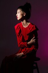 Fashion asian female model in red romantic dress with frills and bright makeup.