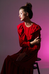 Fashion asian female model in red romantic dress with frills and bright makeup.