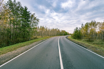 Fototapeta premium A road with trees on the side and a clear blue sky
