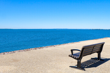 Fototapeta premium A beautiful sunny day, clear and blue sky, sunshine and seagulls flying along the sea at Wynnum jetty, Manly, Suburbs of Brisbane CBD 