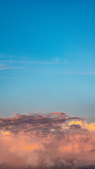 Fototapeta premium red clouds during golden hour against a clear blue sky in the background, photographed in the afternoon when the weather is clear