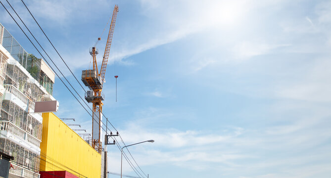 Tower Crane Standing Tall at an Urban Construction Site Under the Bright Blue Sky