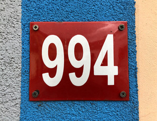 Red metal sign that says number 994