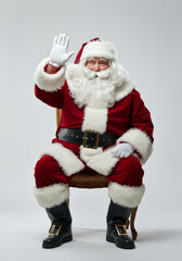 Fototapeta premium Santa Claus Smiling, Sitting and High Five to the Camera Pose Full Body on White Background 02