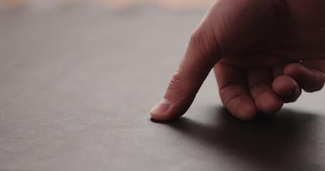 man hand checking brown leather piece closeup