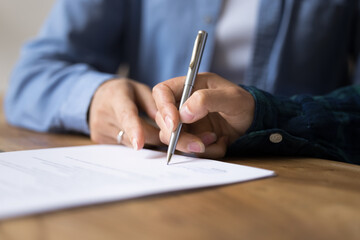 Businesspeople gathered at business meeting after successful negotiations signing contract, confirm...