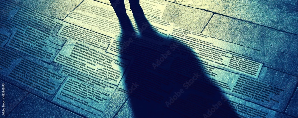 Poster a shadow casts over engraved text on a surface, creating a contemplative atmosphere.