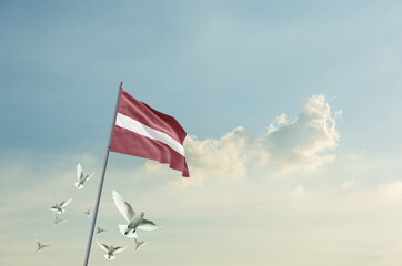 Latvia flag waving with flying doves in beautiful sky. Latvia flag for Republic Day and...