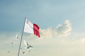 Fototapeta premium Malta flag waving with flying doves in beautiful sky. Malta flag for Republic Day and Independence Day.