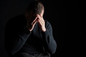 Emotional Struggle: A Man in Contemplation against a Dark Background
