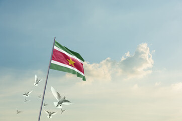 Suriname flag waving with flying doves in beautiful sky. Suriname flag for Republic Day and...