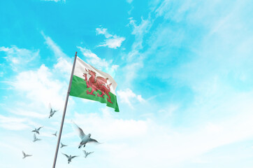 Wales flag waving with flying doves in beautiful sky. Wales flag for Republic Day and Independence...