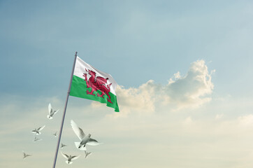 Wales flag waving with flying doves in beautiful sky. Wales flag for Republic Day and Independence...
