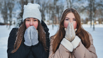 Two young freezing friends shivering on a winter's day.