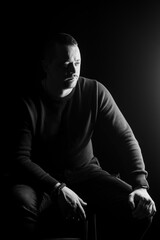 Introspective Man in Dramatic Black and White Lighting