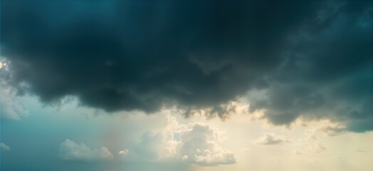 Dramatic cumulus clouds gather before storm. Fluffy white clouds contrast dark stormy clouds. Sunlight peeks through dark clouds. Beautiful sky view. Ominous weather pattern. High fluffy clouds.