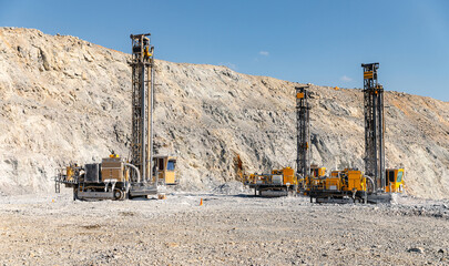 Modern Drilling Machines in Open-Pit Mine against Rocky Terrain