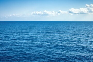 Obraz premium A serene view of the ocean under a clear blue sky with gentle waves.