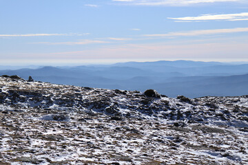Snow-covered terrain with mountains in the background
