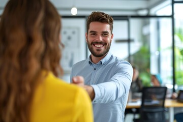 Obraz premium Young Caucasian businessman smiling and reaching out for a handshake in a modern office setting during the daytime