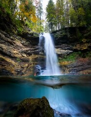 Cascada en medio de un bosque frondoso, vista desde abajo