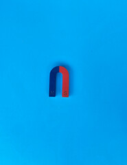 Simple magnetic arc on a bright blue background highlighting the north and south poles of the...