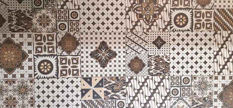 A top-view photo of floor tiles with Central Java batik patterns in white and brown tones. Batik is a traditional Indonesian art using wax-resist dyeing techniques for intricate designs
