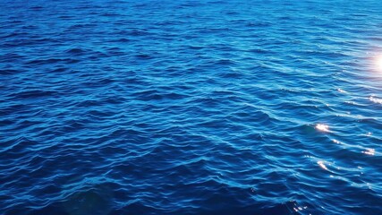 Rippling deep blue sea with sunlit highlights, creating a serene and tranquil texture, calm, tranquil