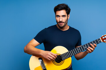 Obraz premium Guy plays blues on white . music male man concept. guy standing with a guitar on blue . a guy with a blue guitar and a musician standing in the lifestyle.