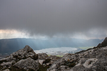 A lake between the rocks in the mountains with stormy sky