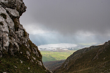 A lake between the rocks in the mountains with stormy sky