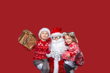 Fototapeta premium A Santa Claus with two happy children and presents.