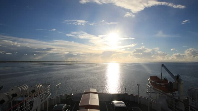 Timelapse of a ferry sailing over the Waddensea during sunset. Holwerd, The Netherlands