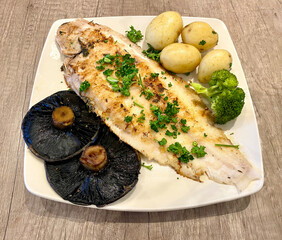 Grilled Dover sole fish with new potatoes, broccoli and large mushrooms making a luxury meal