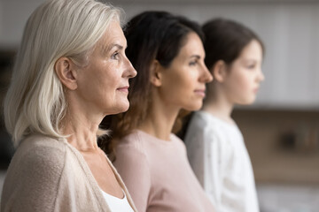 Profile side faces view of serious attractive grandmother posing with grown up daughter and little...
