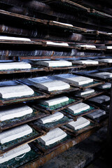 Worker making tofu in a traditional family factory. Tofu is a food prepared by coagulating soy...