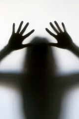 Silhouette of a woman behind the glass. Woman showing gesture stop. Stop violence and sexual abuse...