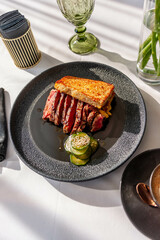 Hearty breakfast with beef steak, toast and crushed cucumbers