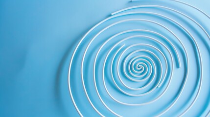 Obraz premium Spiral Coil on Blue Background - a striking and modern visual. The blue backdrop enhances the coil's design, creating an engaging scene.