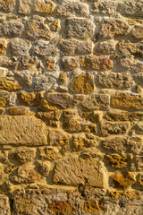 Ancient stone yellow wall of the fortress uneven rough texture